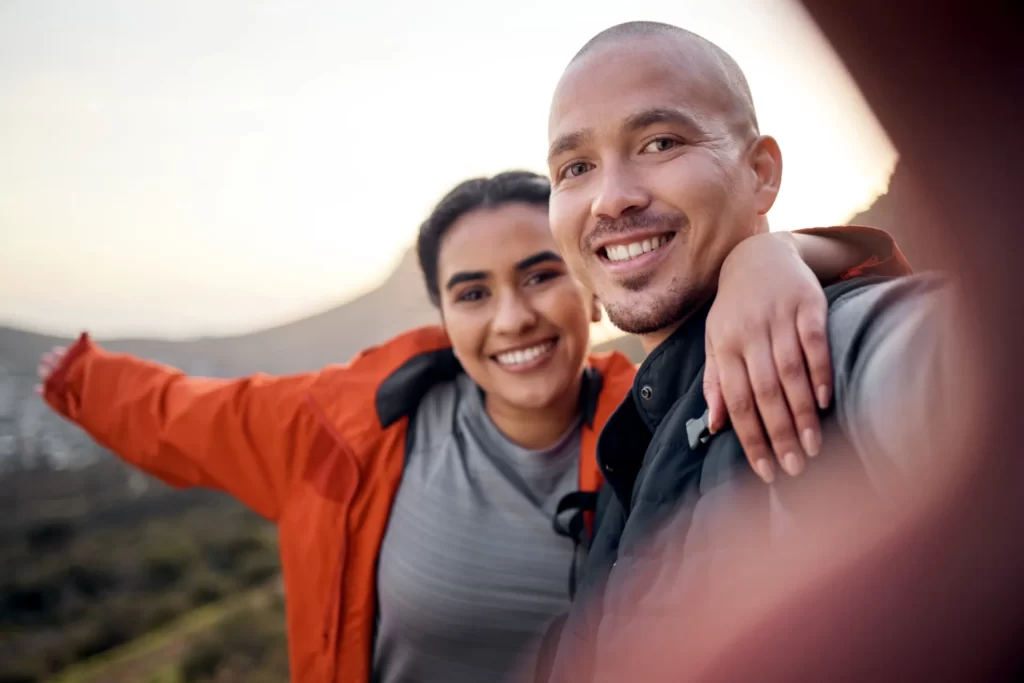 cheerful couple hiking during golden hour utc