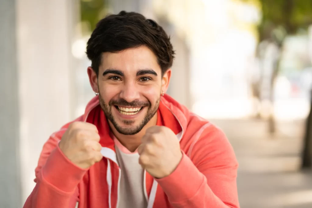 happy young man posing with upraised fists utc